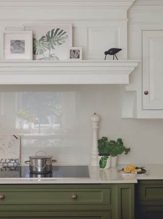Olive green and white kitchen by Tom Howley with white glass backsplash