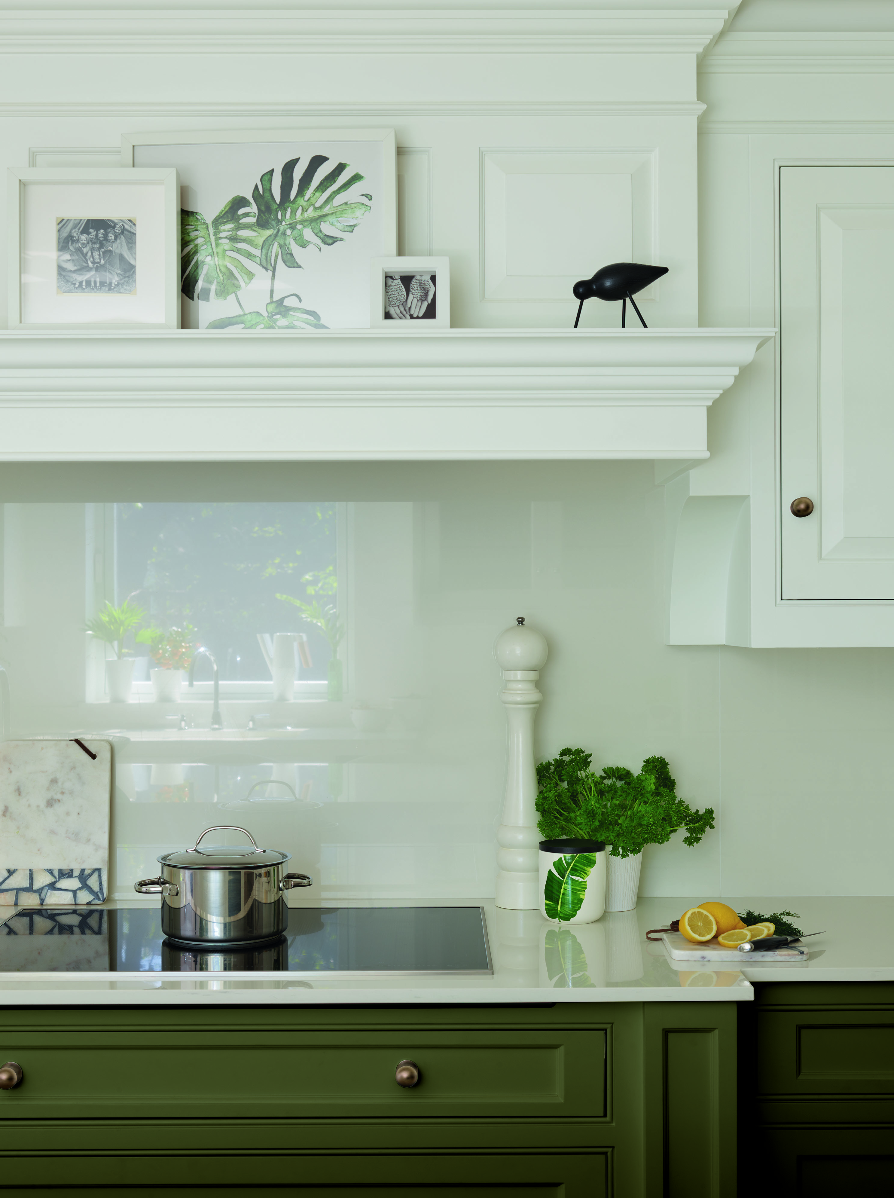 Olive green and white kitchen by Tom Howley with white glass backsplash