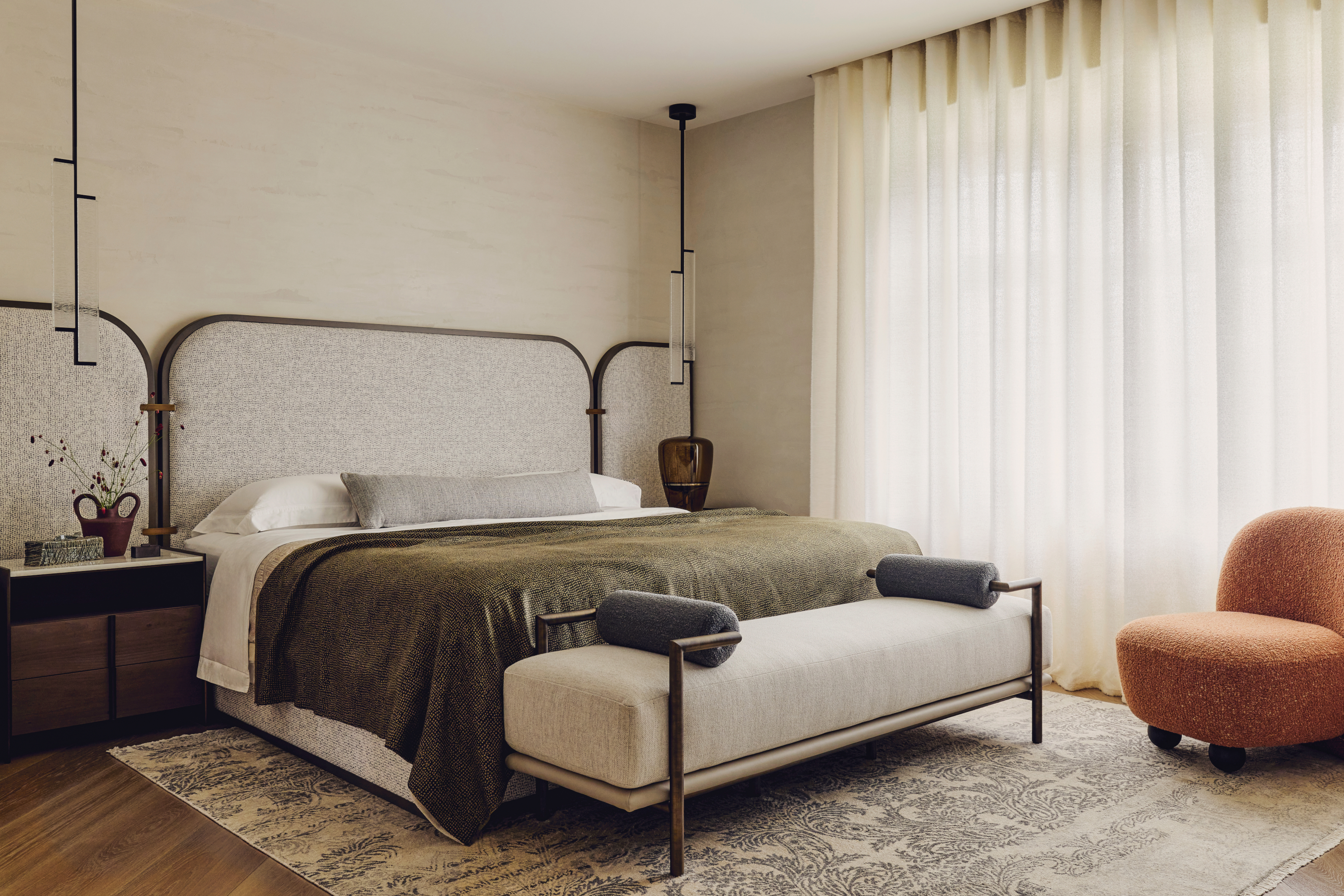 Cream bedroom with oversized headboard and moss green throw