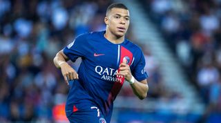 Kylian Mbappe of PSG running during a match as Manchester City try to keep Erling Haaland