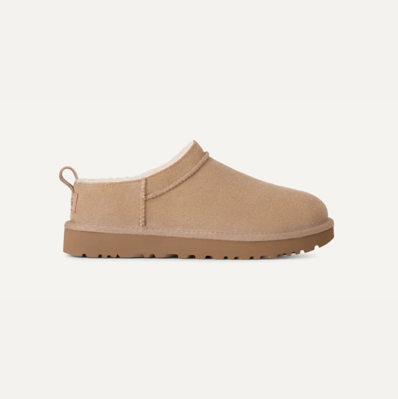 a pair of sand toned ugg micro boots in front of a plain backdrop
