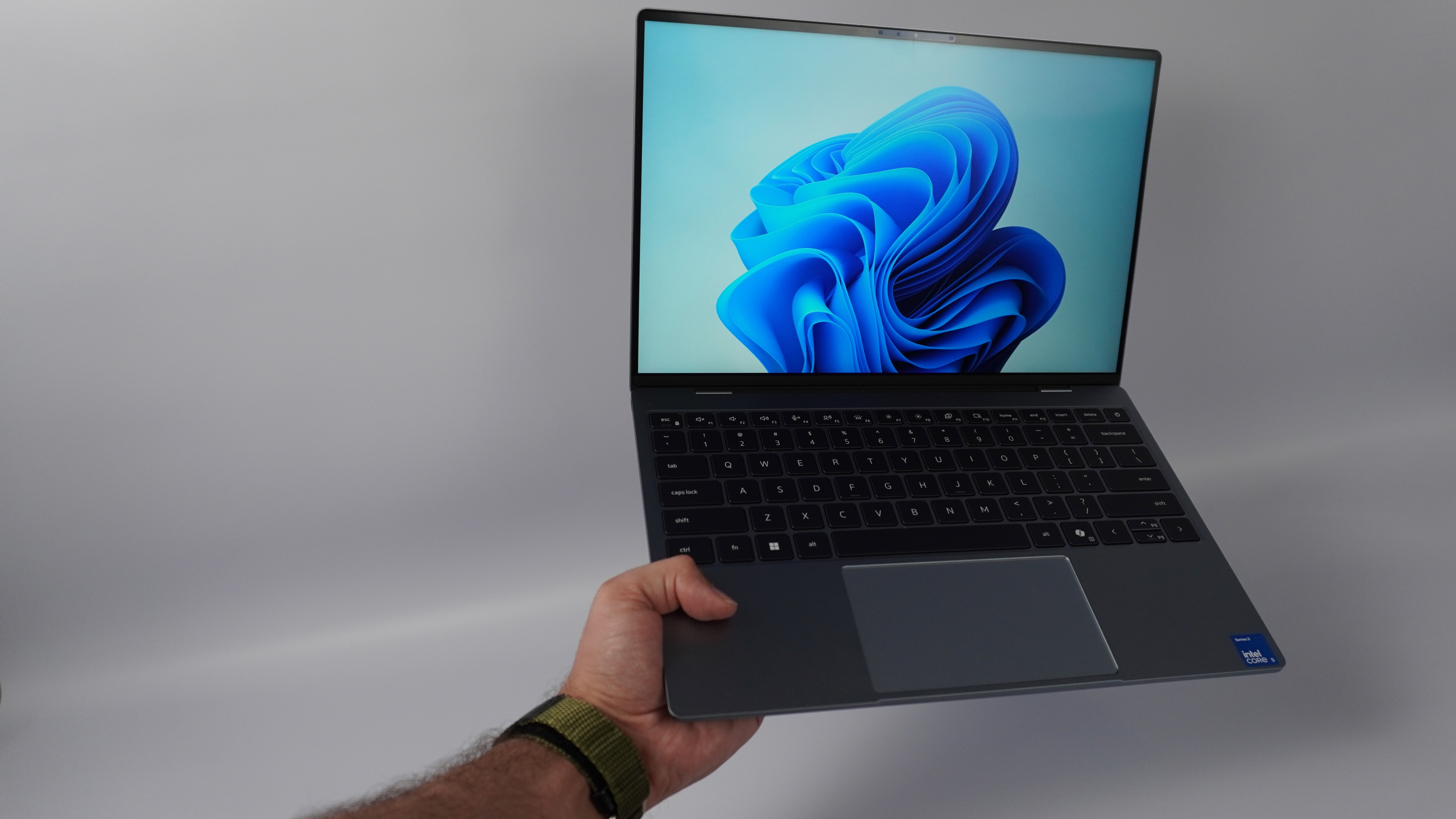 شخصی که Dell XPS 13 (2026) را در یک دست دارد
