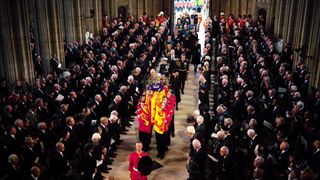 King Charles III and Camilla, Queen Consort follow behind the coffin of Queen Elizabeth II