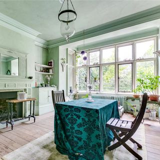 green dining room with table and wooden flooring