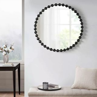 Decorative black round wall mirror on wall