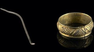 A silver toilet spoon and a silver-gilt ring.