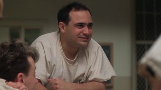 Danny Devito smiling and looking confused in a white tee shirt in One Flew Over The Cuckoo's Nest