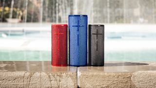 the ue boom 3 bluetooth speaker in three different shades: red, blue, and black