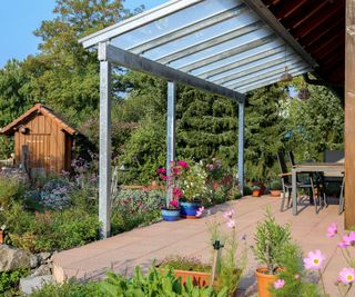 A patio cover with a view of a wooden garden shed