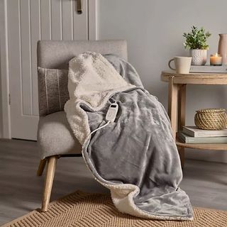 Lakeland Sherpa Electric Heated Throw Grey on a chair in a living room