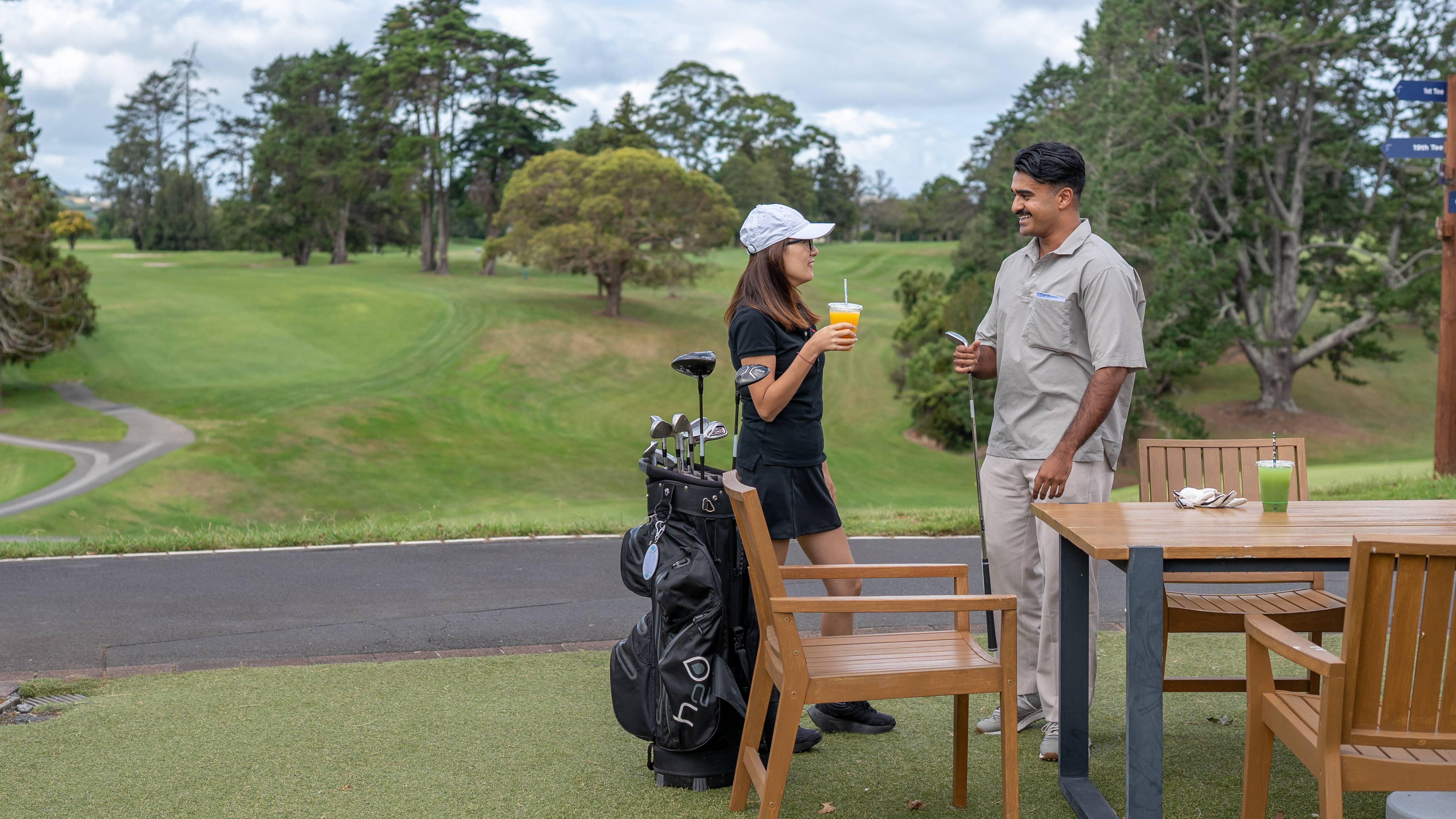 Male and female golfer having a drink