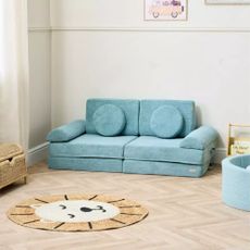Tutti Bambini Montessori Kids Play Sofa in Ocean Stone in a kids' room with a lion head-shaped rug