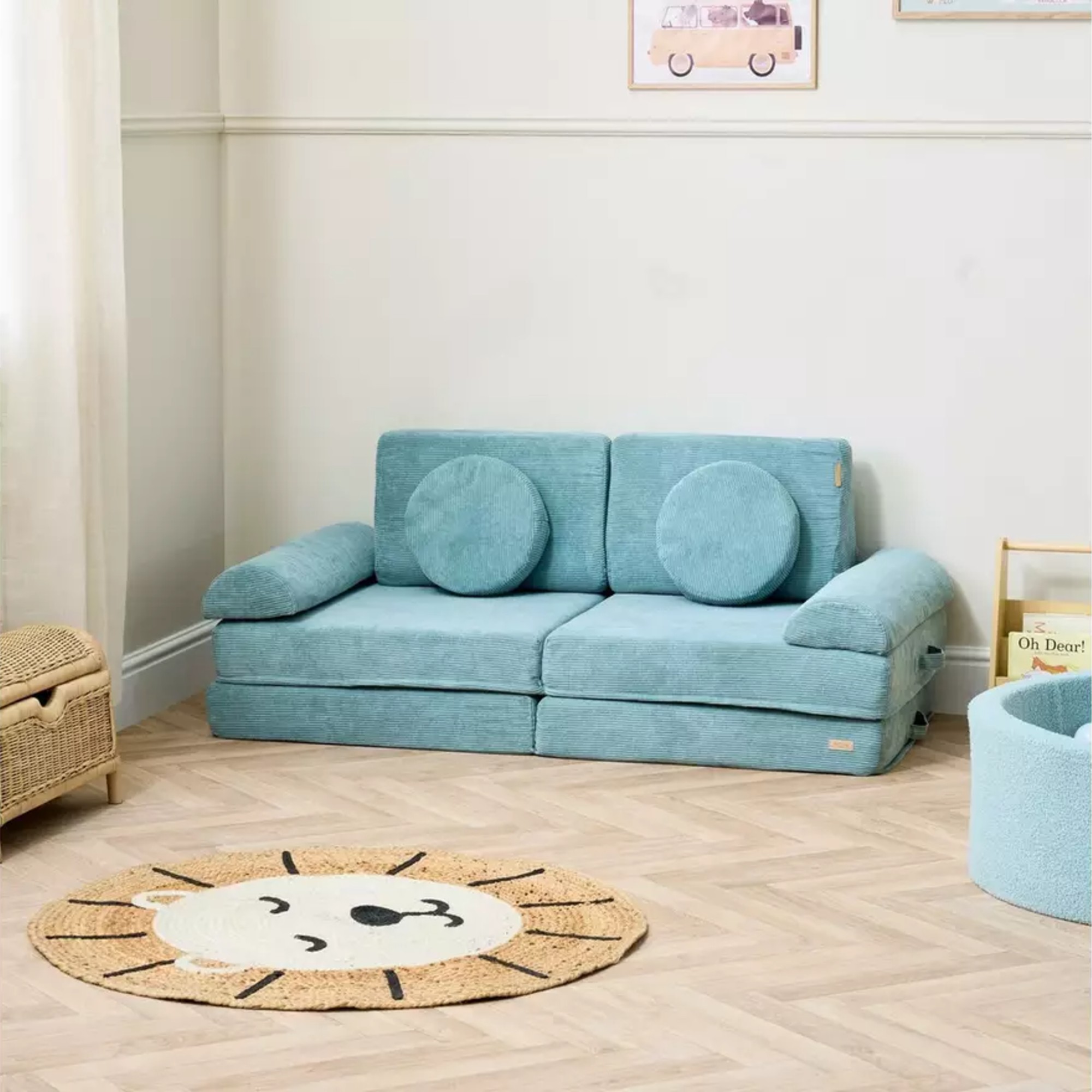 Tutti Bambini Montessori Kids Play Sofa in Ocean Stone in a kids' room with a lion head-shaped rug