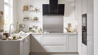 small pale grey kitchen with stainless steel splashback