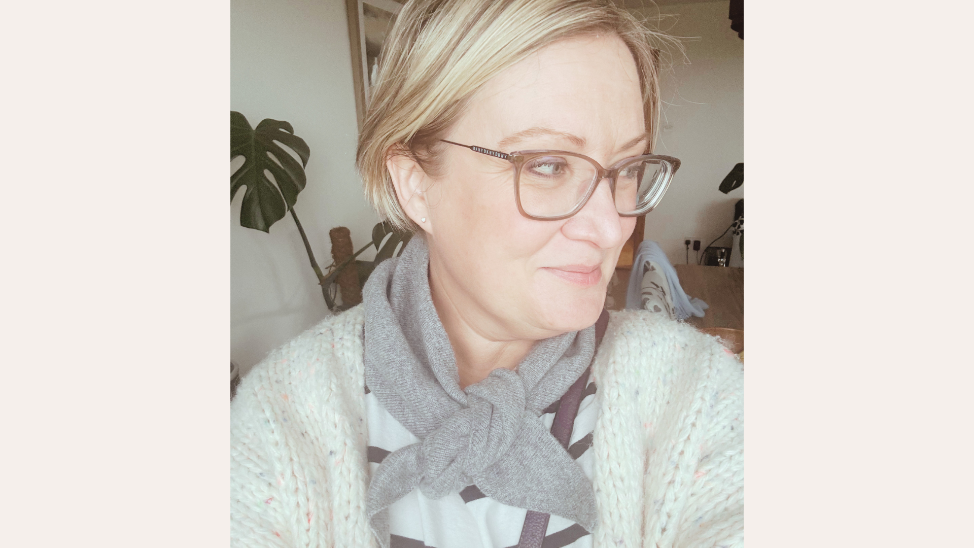 Writer Heidi Scrimgeour wearing a grey triangle scarf, looking away, styled casually