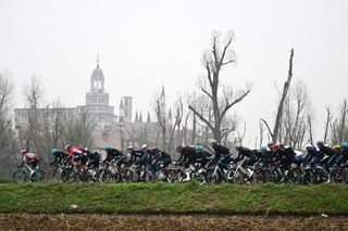 Riders take the start of the Milan - Sanremo one-day classic cycling race, in Pavia, near Milan, on March 22, 2025. In the background the Certosa di Pavia. (Photo by Marco BERTORELLO / AFP)