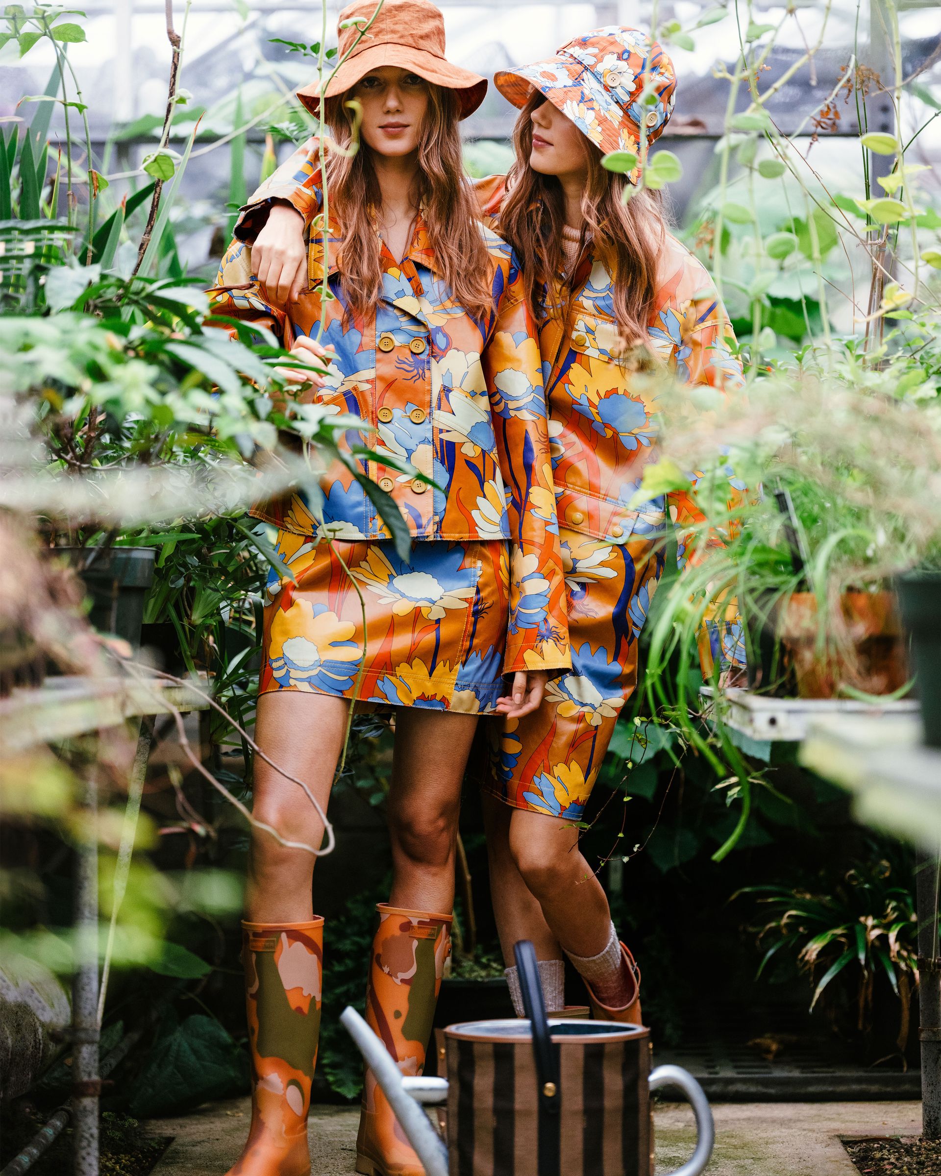 women in floral rain boots, jacket, hat and skirt