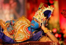 A girl dressed up as Hindu Lord Krishna performs during Janmashtami festival celebrations marking the birth of Lord Krishna, in Ahmedabad, India.