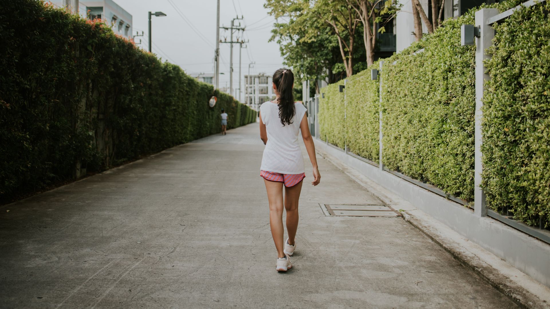 Woman with her back to the camera walking away in activewear and trainers