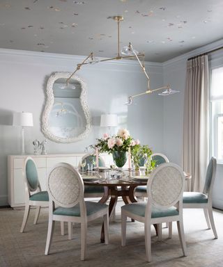 dining room with wallpaper and pale blue chairs