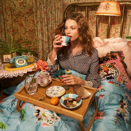 model lounging in summer pajamas in bed with a plate