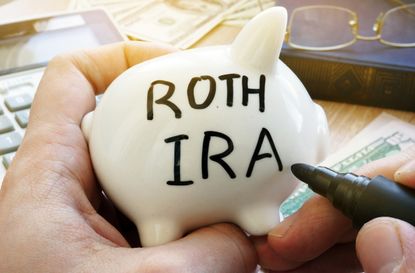 Hands holding piggy bank with Roth IRA. Pension plan.