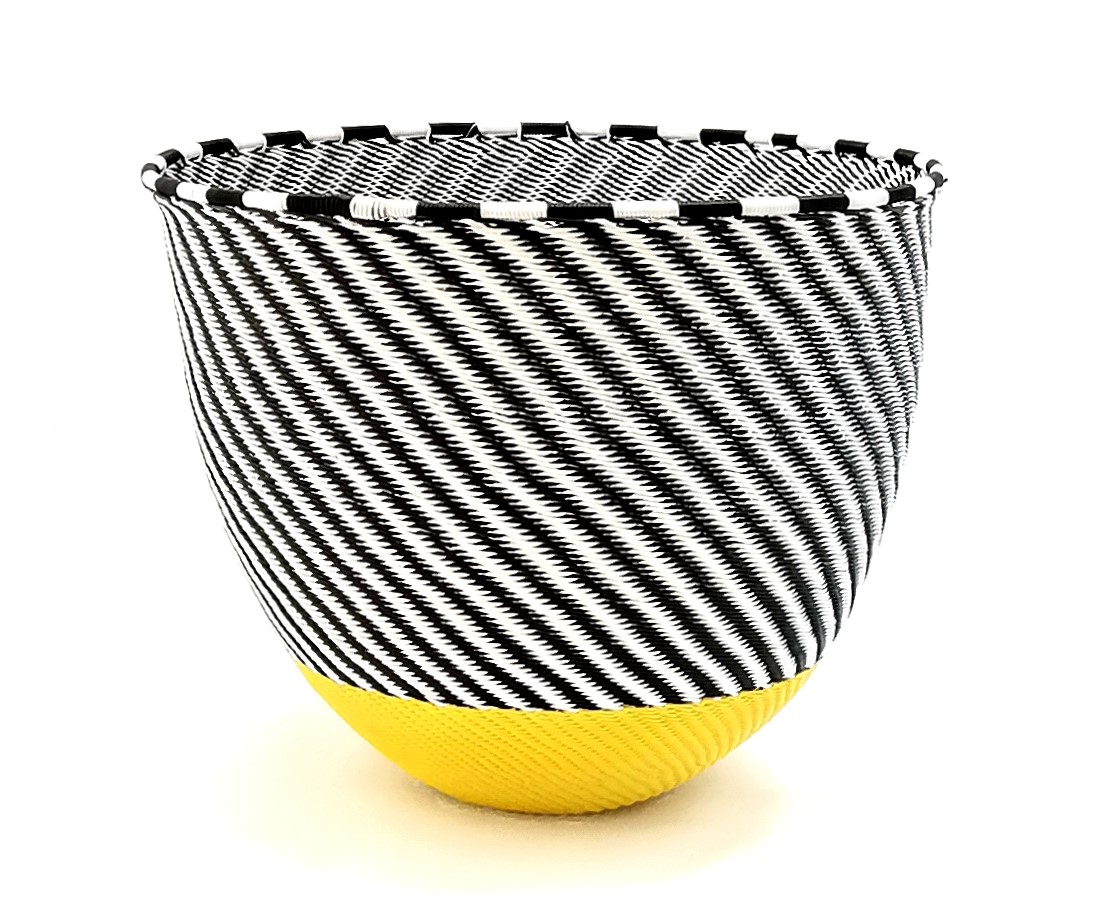 A black and white striped bowl with a yellow bottom made of telephone wire