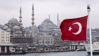 A harbour in Istanbul with the Turkish flag at the forefront.