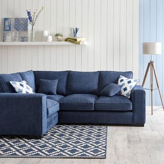 white wall with blue sofa set and carpet
