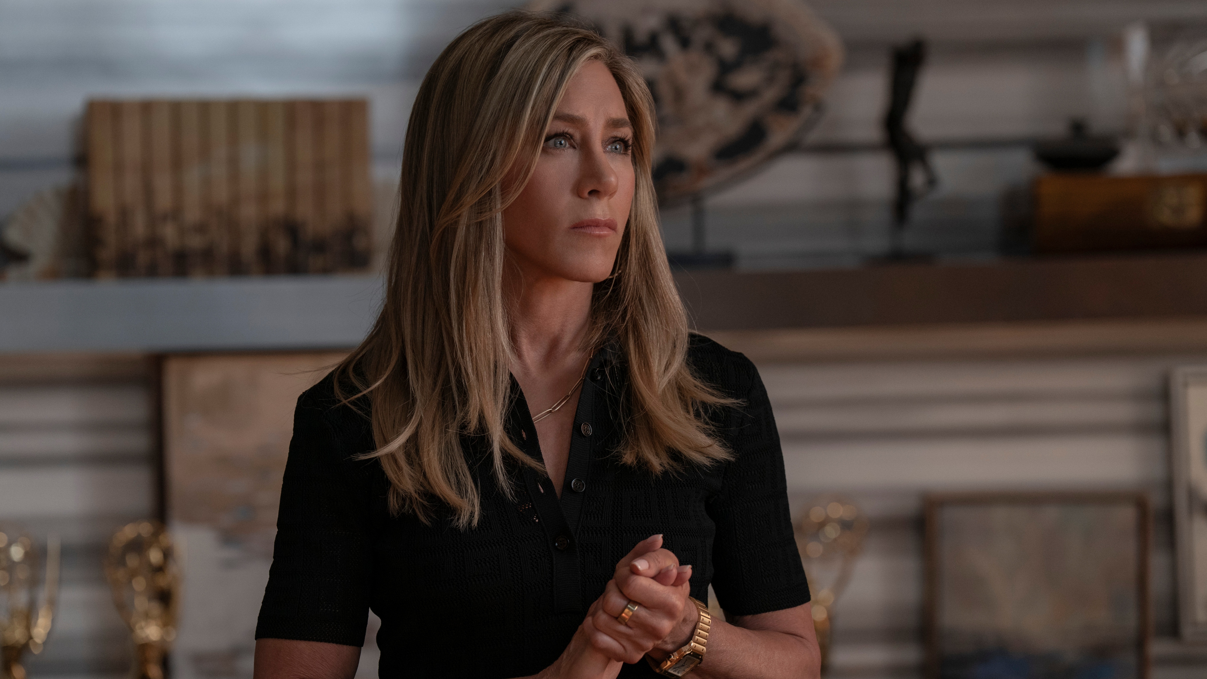 Jennifer Aniston as Alex in a black dress and looking serious in The Morning Show season 4