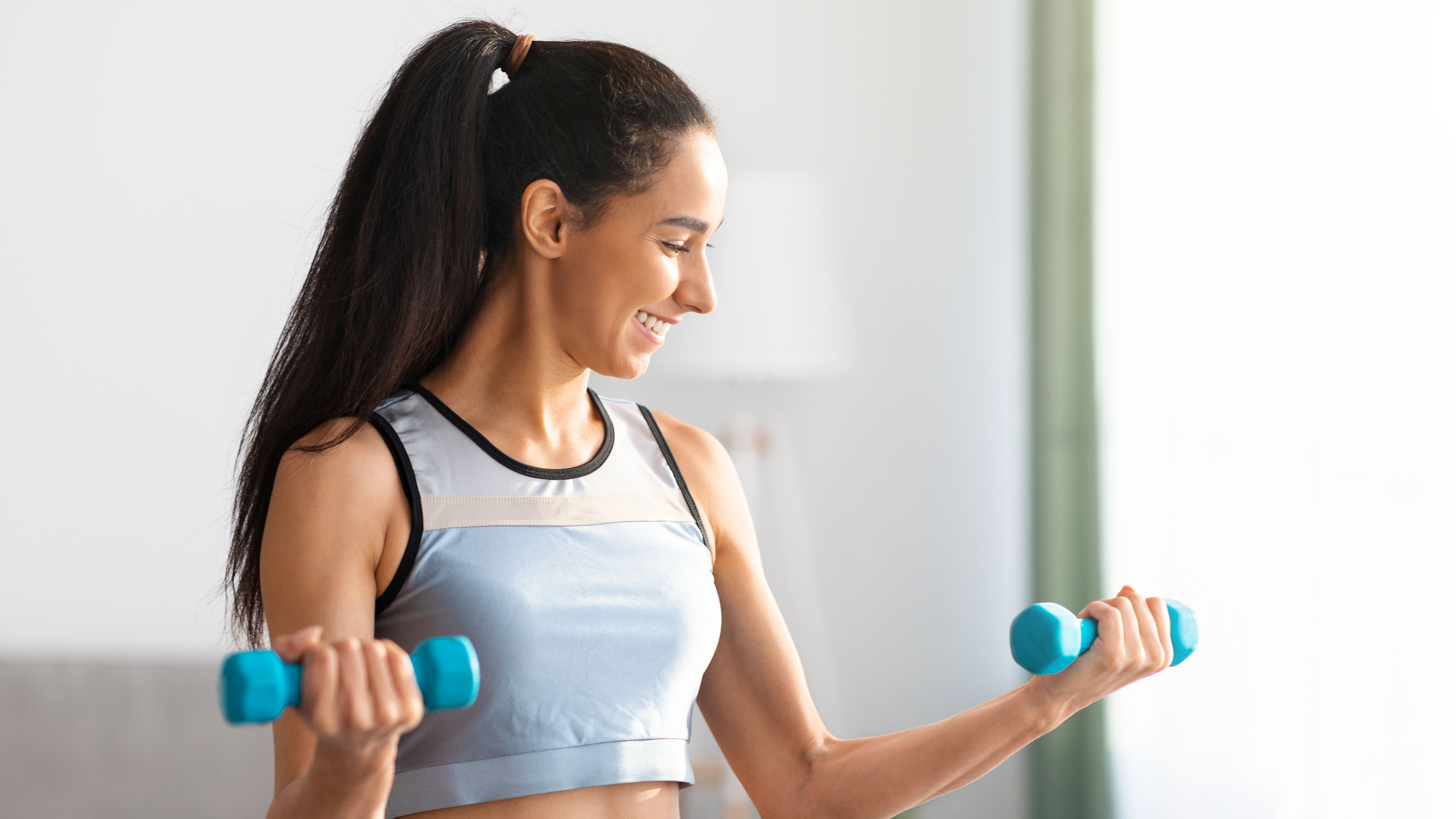 a photo of a woman lifting light dumbbells