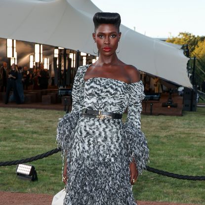 Jodie Turner Smith wearing an off-the-shoulder dress, red lipstick, and an updo