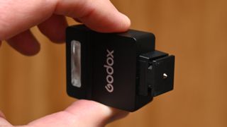 Godox iM22 product shot, held in hand