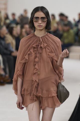 Woman in boho ruffle dress on Chloé runway