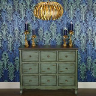 blue designed wall with green drawers candle lamp and brown flooring