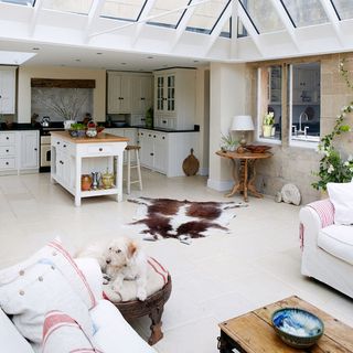 conservatory kitchen area with white kitchen units and tiles floor