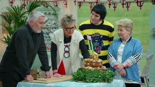 The judges of The Great British Baking Show examine a cake