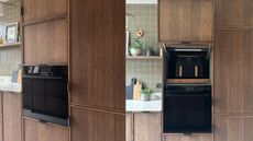 A kitchen with hidden storage for an airfryer that is above an oven and beside the kitchen worktop