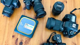 Cameras, lenses and a portable SSD on a table