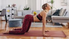 woman does cat-cow pose on yoga mat at home