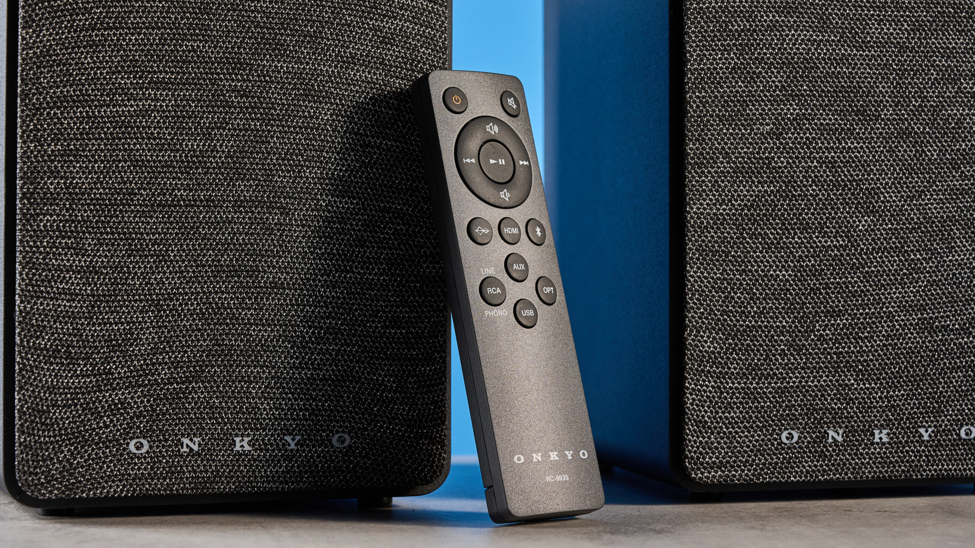 Onkyo GX-30ARC bookshelf speakers photographed on a blue background