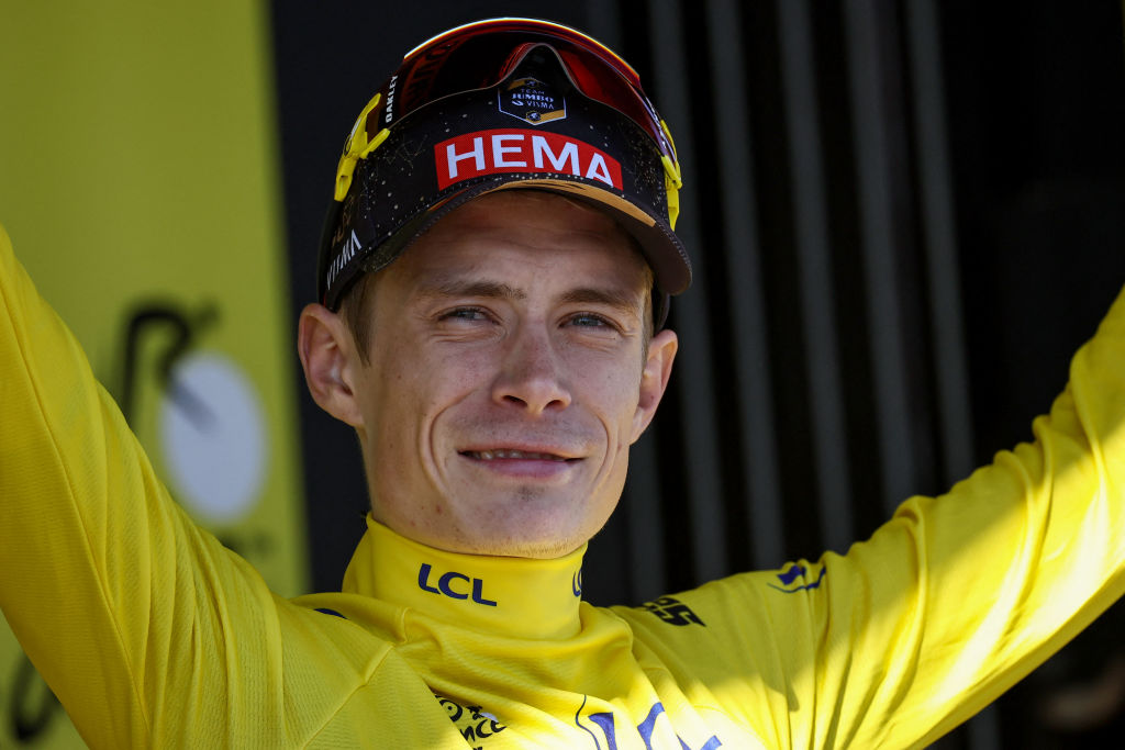 Danish rider Jonas Vinggaard celebrated in Jumbo-Visma on the podium in the overall leader's yellow jersey after stage 13 of the 110th edition of the Tour de France, 138 kilometers between Châtillon-sur-Chalaron in central-eastern France and Grand Colombier, in the eastern Jura mountains. France, July 14, 2023 (Photo by Anne-Christine Pugolat/AFP)