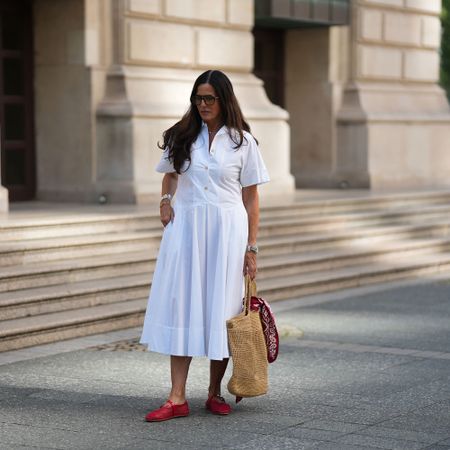 a woman wears a white shirtdress
