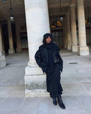 Franny Fyne wears a black maxi dress and wool coat