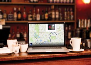 Laptop in a cafe displaying a map route