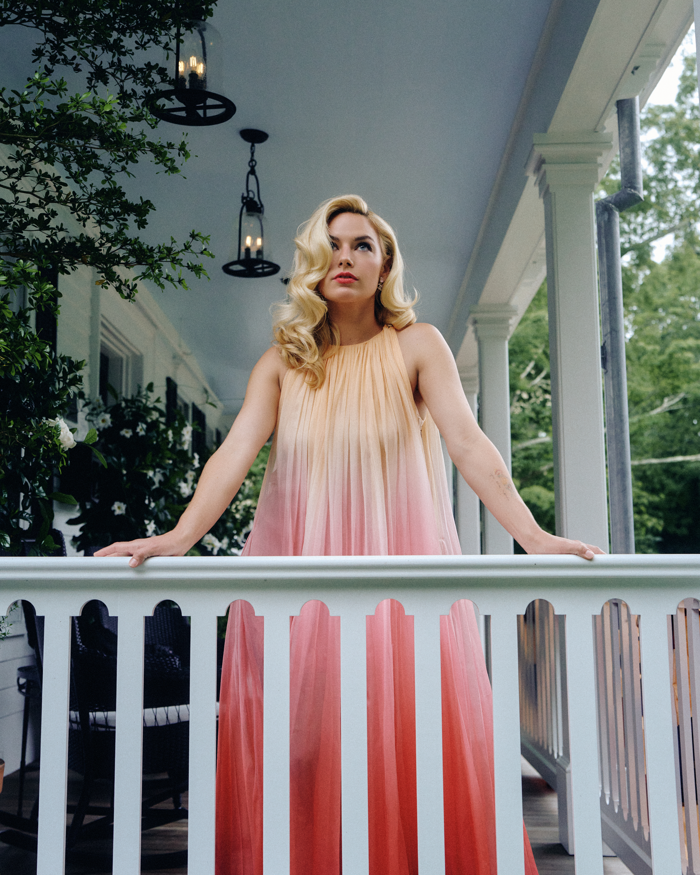 Ashe poses on a balcony wearing a Chanel gown