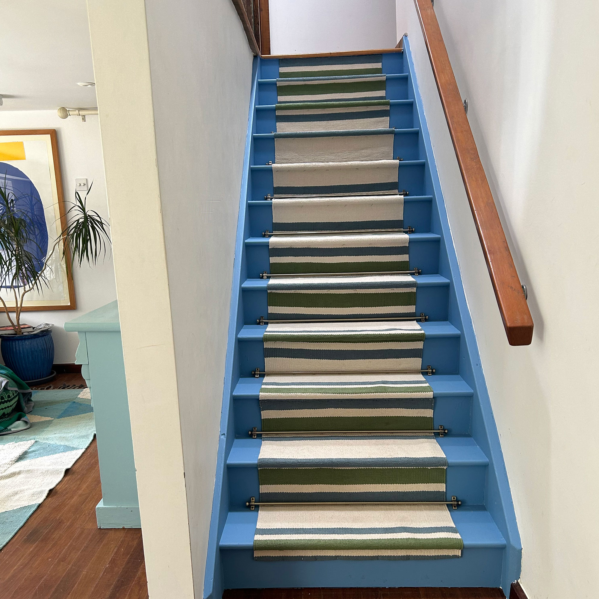 Blue staircase with striped fabric runner