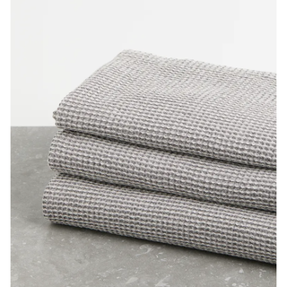 3 grey waffled towels folded in a pile