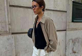 woman in beige coat, cardigan and white pants