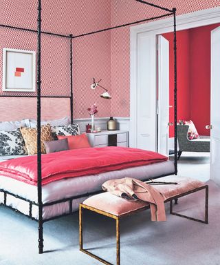 Pink themed room. Black four poster bed, red patterned wallpaper